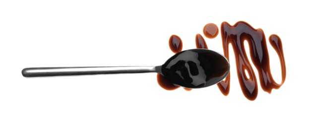 Smear of soy sauce and spoon on white background, top view