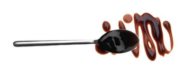 Photo of Smear of soy sauce and spoon on white background, top view