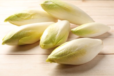 Photo of Raw ripe chicories on wooden table, closeup