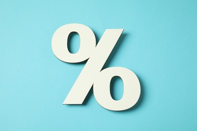 Photo of White percent sign on light blue background, top view