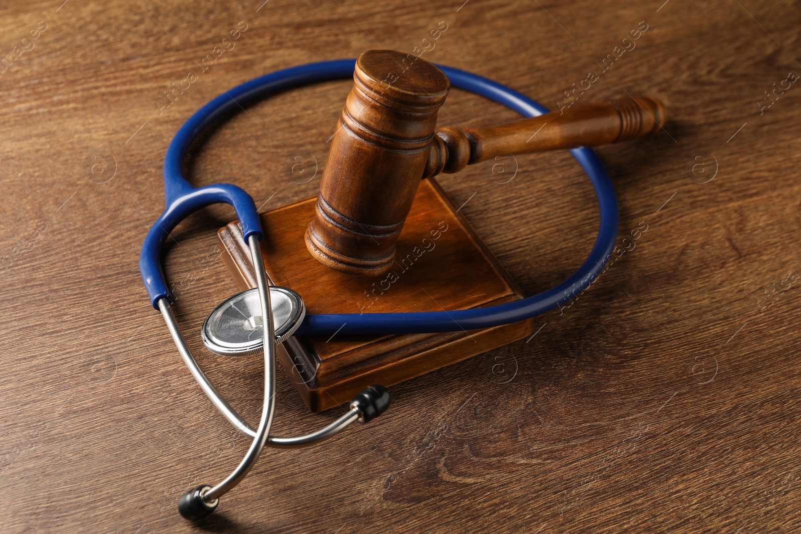 Photo of Law concept. Gavel and medical stethoscope on wooden table