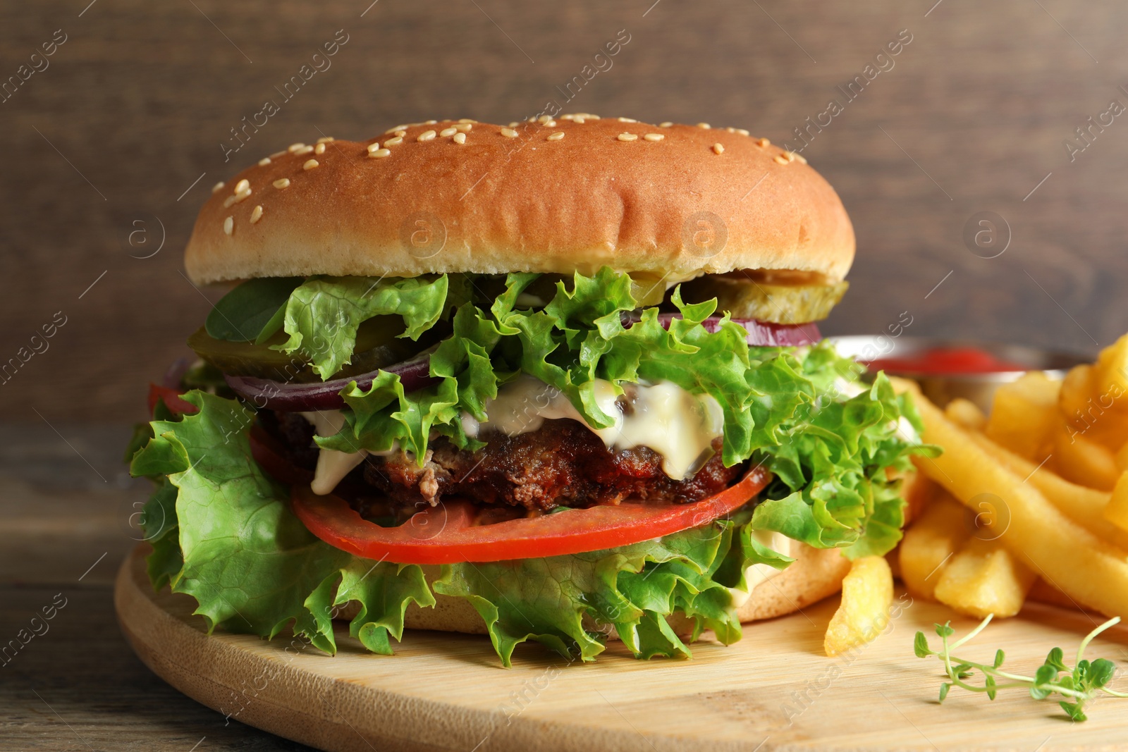 Photo of Delicious burger with beef patty and french fries on wooden table, closeup