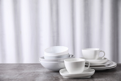 Photo of Set of clean dishware on grey table