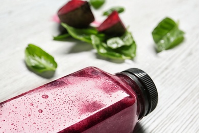 Photo of Bottle of beet smoothie on table, closeup