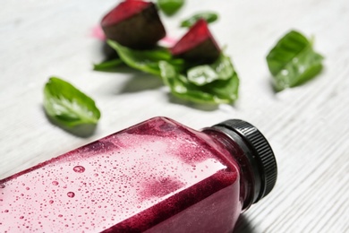 Bottle of beet smoothie on table, closeup