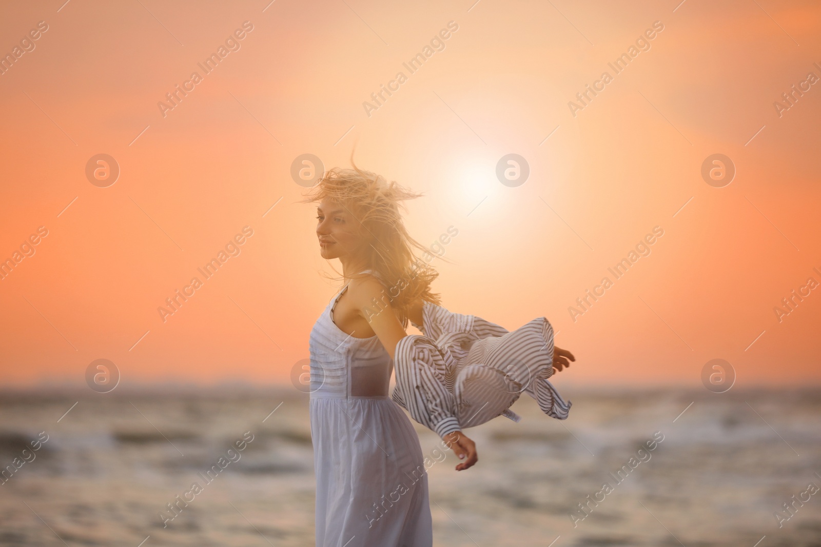 Photo of Beautiful young woman on beach at sunset