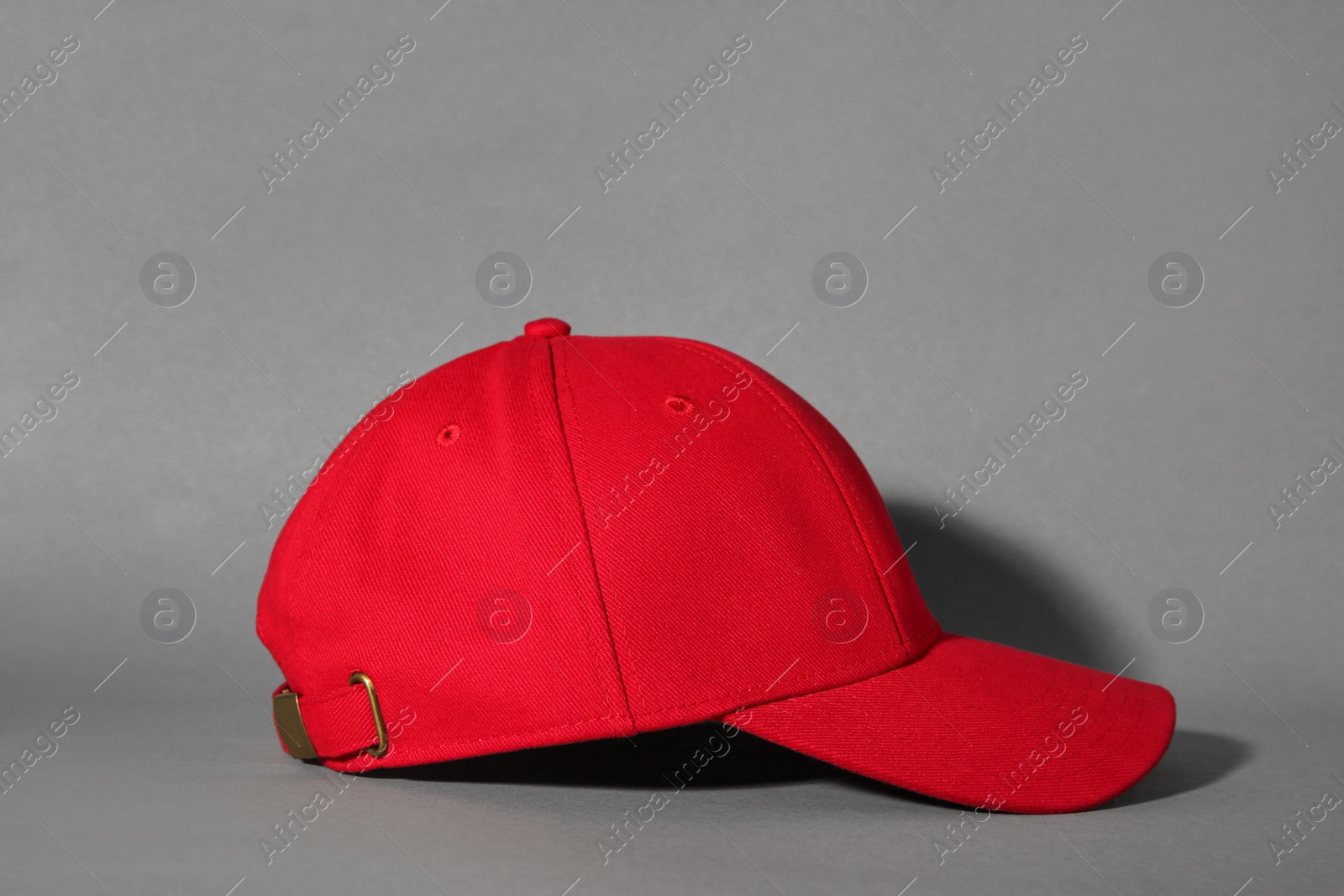 Photo of Stylish red baseball cap on grey background