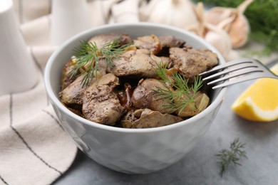 Tasty fried chicken liver with dill and fork on grey table, closeup