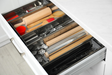 Photo of Different utensils in open desk drawer indoors