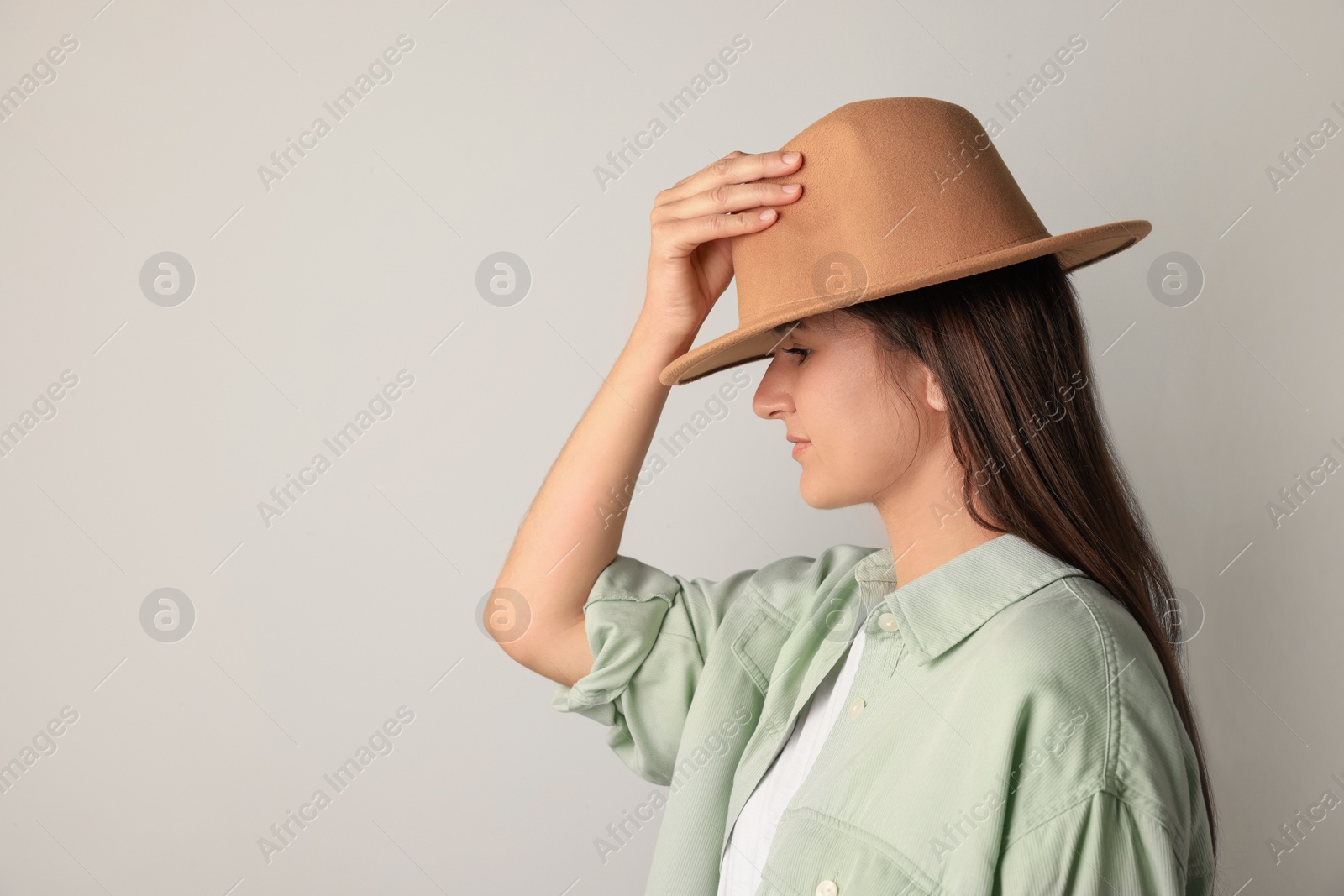 Photo of Young woman in stylish outfit on light background. Space for text