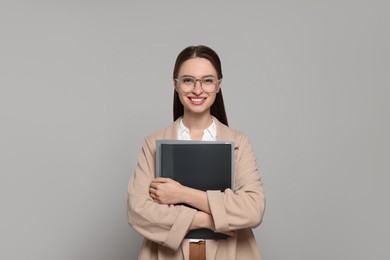 Portrait of beautiful young teacher on grey background