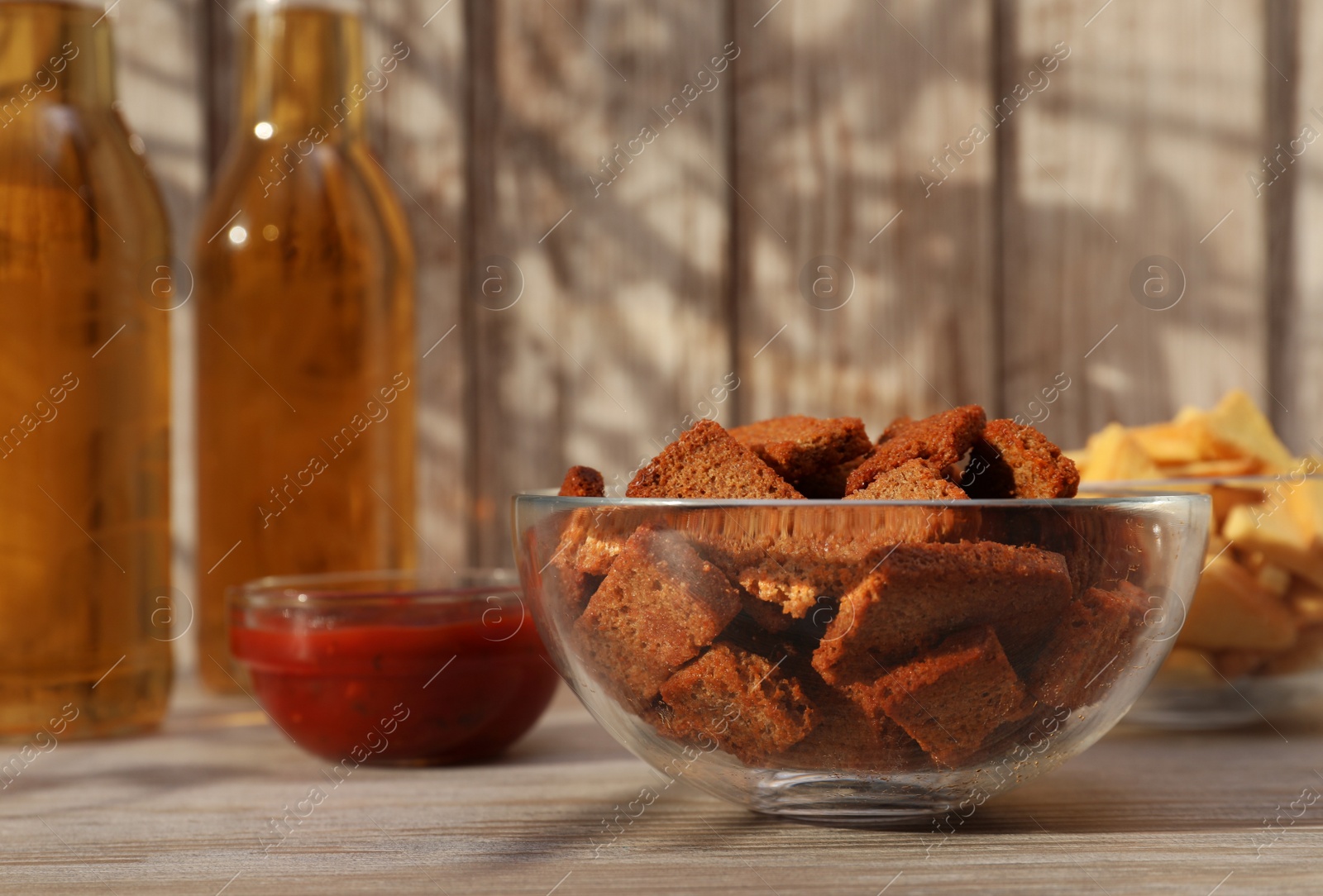 Photo of Crispy rusks, beer and dip sauce on wooden table