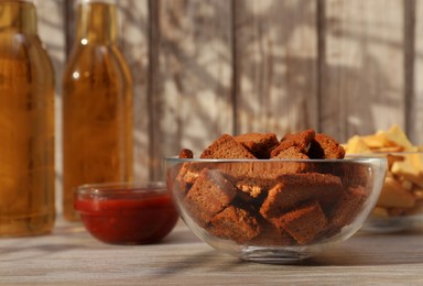 Crispy rusks, beer and dip sauce on wooden table