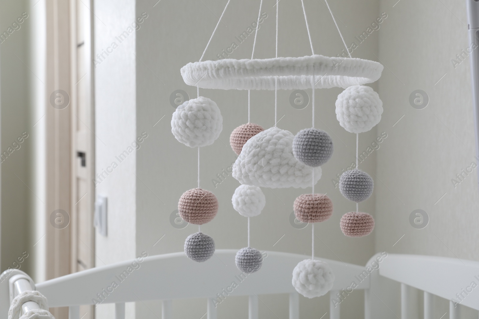 Photo of Modern baby mobile under crib in children's room