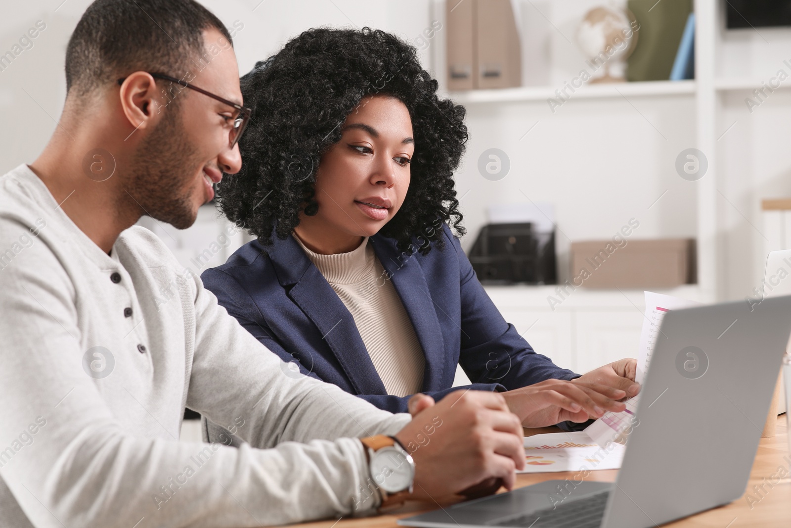 Photo of Young colleagues working together at table in office