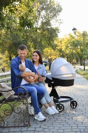 Photo of Happy parents with their baby on bench in park