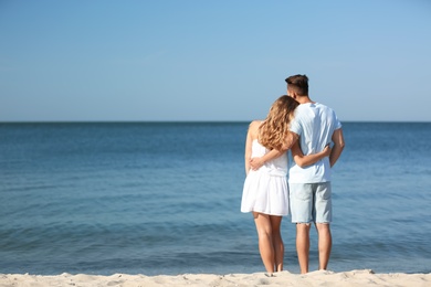 Happy young couple at beach on sunny day