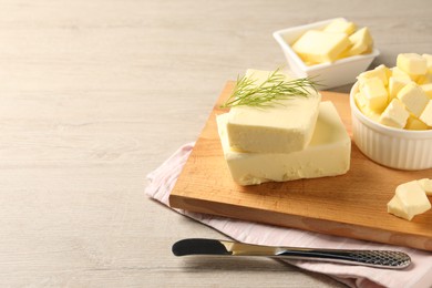 Photo of Tasty butter with dill and knife on wooden table. Space for text