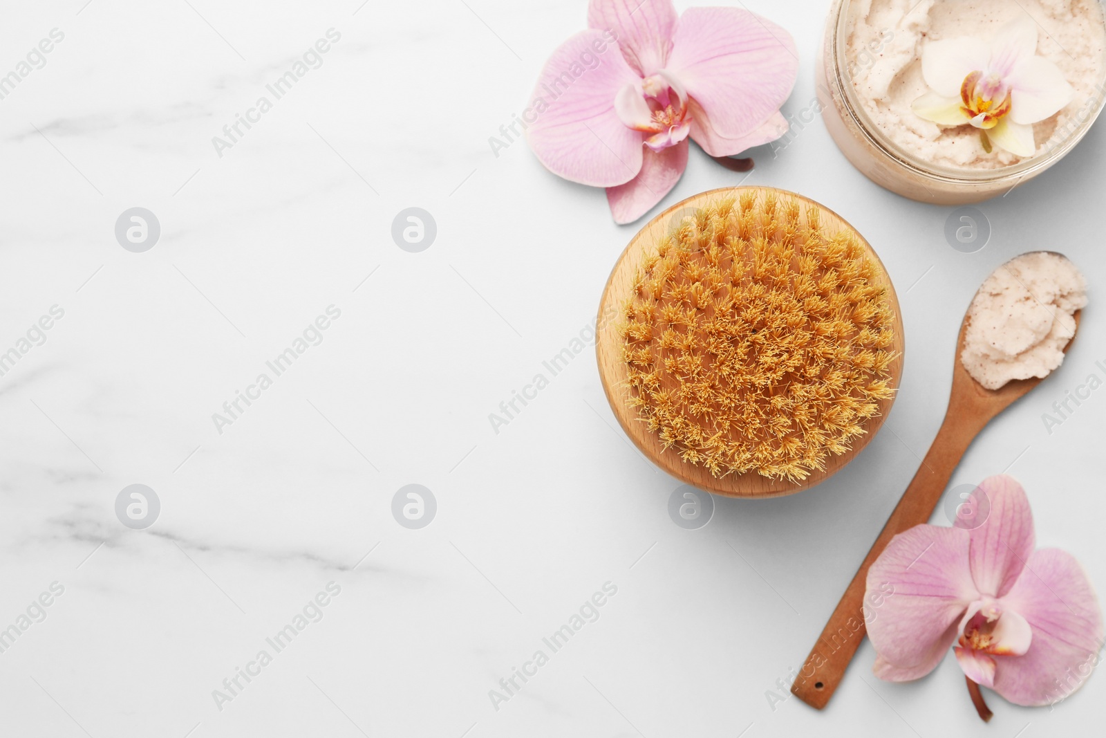 Photo of Flat lay composition with spa products and flowers on white marble table. Space for text