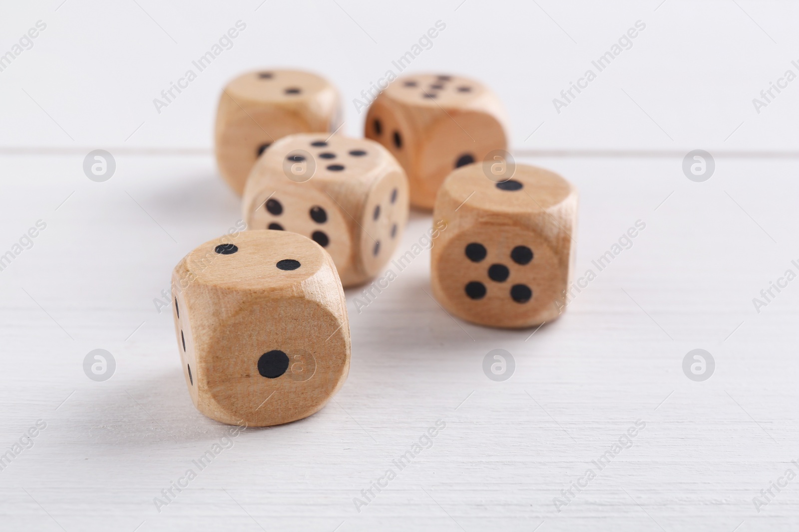 Photo of Many game dices on white wooden table, closeup