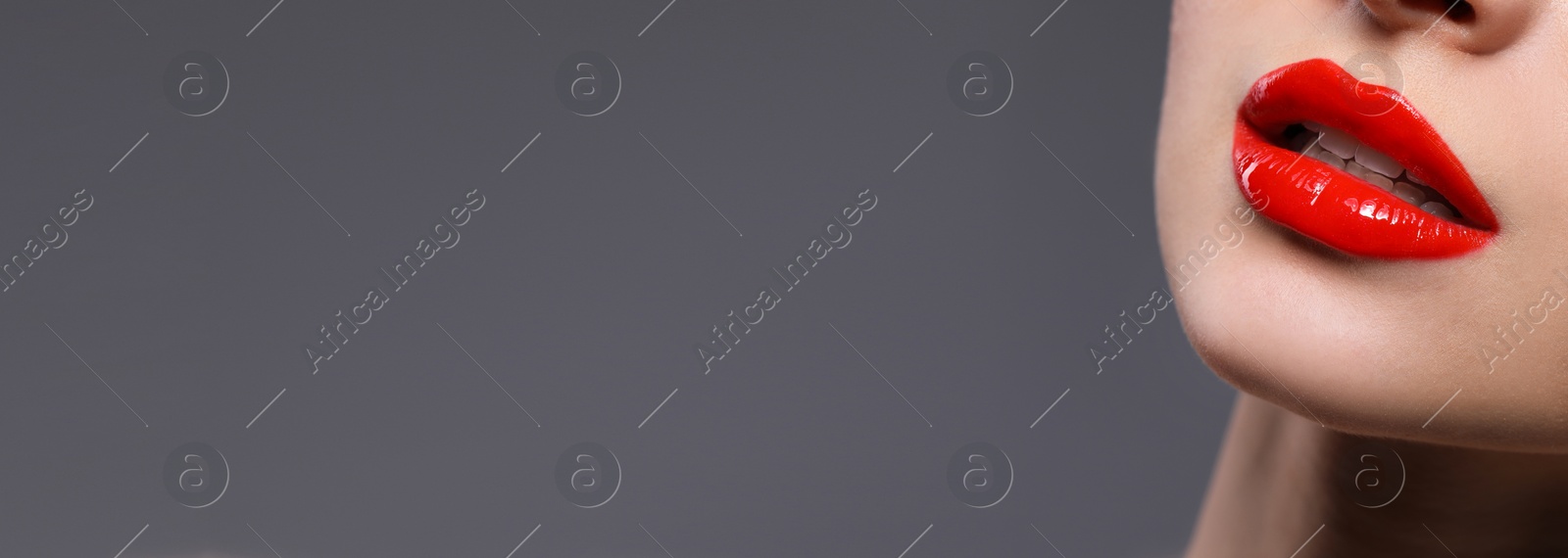 Image of Woman with beautiful red lips on grey background, closeup view with space for text. Banner design