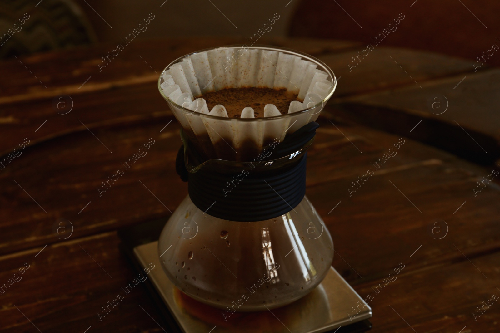 Photo of Cup with wave dripper and coffee on wooden table in cafe