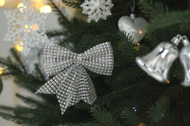 Photo of Closeup of beautiful bow hanging on Christmas tree