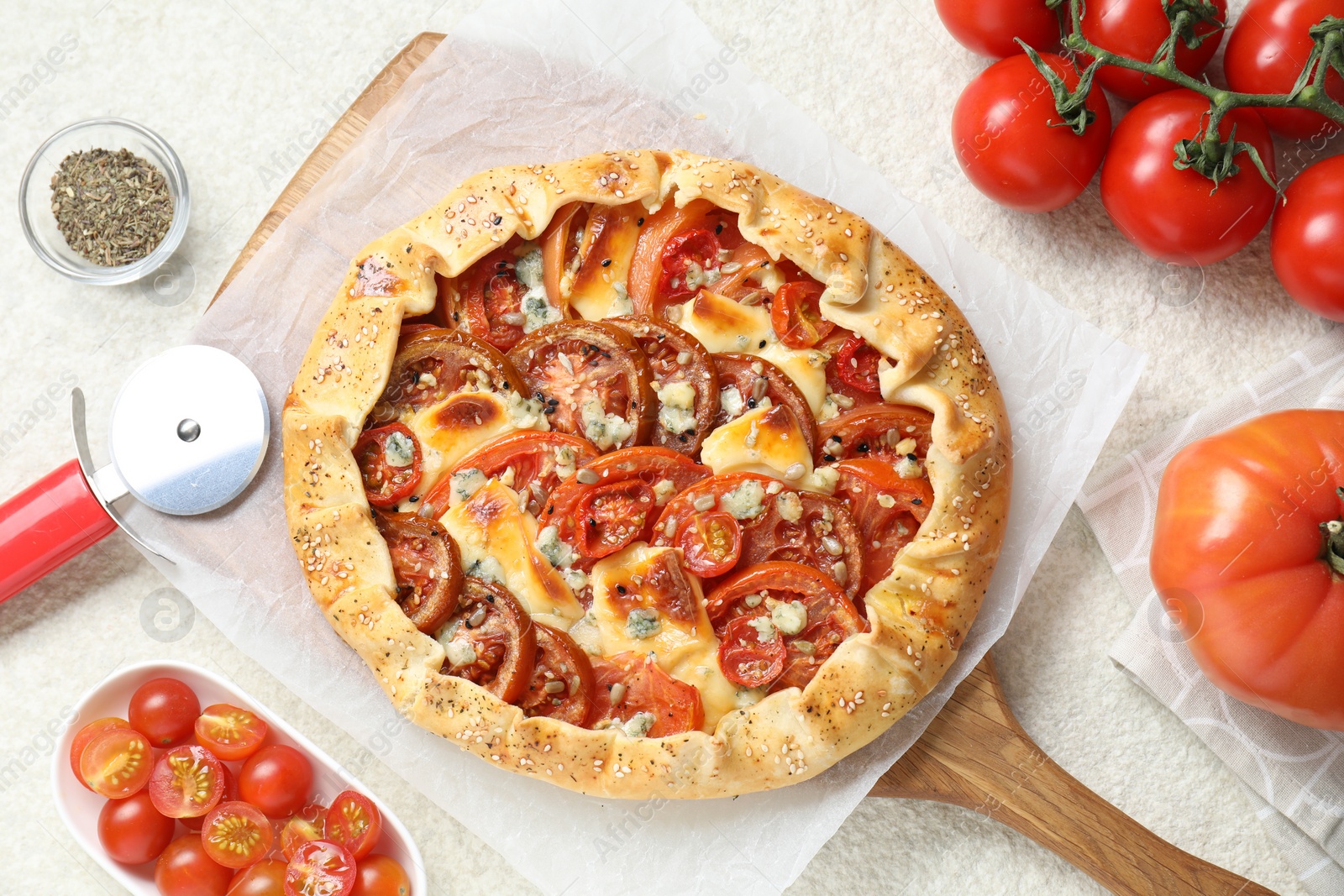 Photo of Flat lay composition of tasty galette with tomato and cheese (Caprese galette) on light textured table