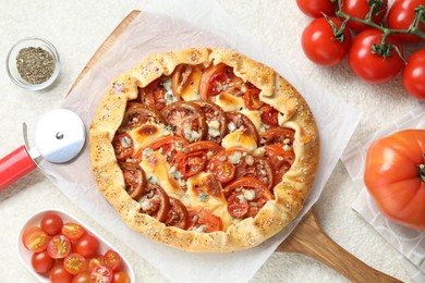 Flat lay composition of tasty galette with tomato and cheese (Caprese galette) on light textured table