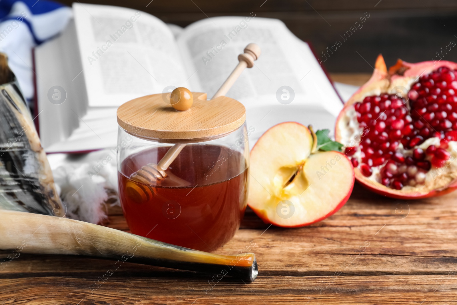 Photo of Honey, pomegranate, apples and shofar on wooden table. Rosh Hashana holiday