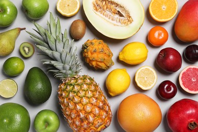 Photo of Many different fresh fruits on light grey table, flat lay