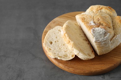 Photo of Freshly baked cut sourdough bread on grey table. Space for text