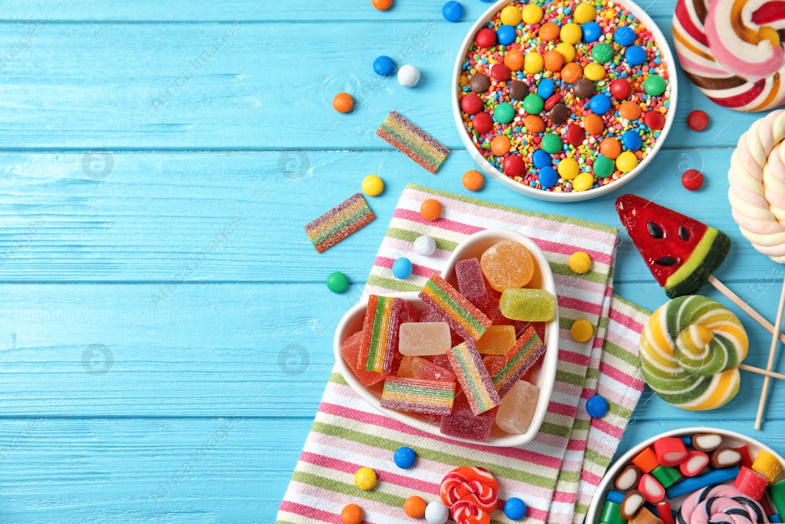 Photo of Flat lay composition with different yummy candies and space for text on color wooden background
