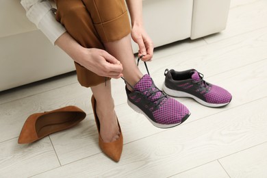 Photo of Woman changing shoes on sofa in office, closeup