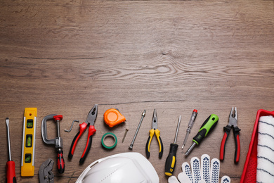 Flat lay composition with different construction tools on wooden background. Space for text