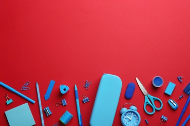 Photo of Blue school stationery on red background, flat lay. Space for text