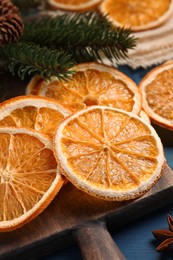 Photo of Dry orange slices and fir tree branches on wooden table, closeup