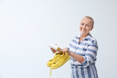 Photo of Woman putting powder shoe freshener in footwear on white background. Space for text