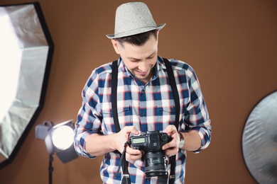 Photo of Professional photographer with camera and lighting equipment in studio