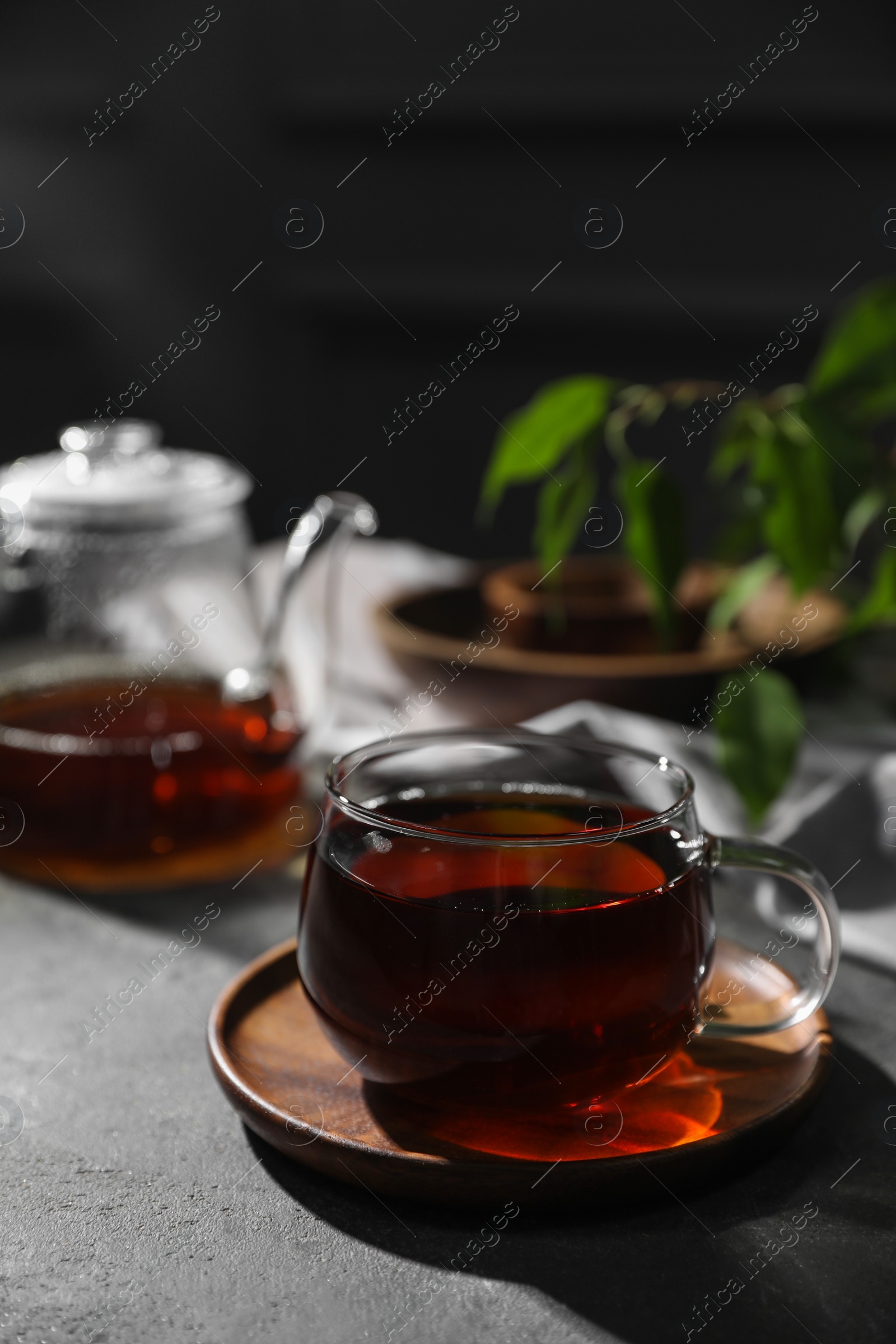 Photo of Tasty hot tea in cup on grey table, closeup