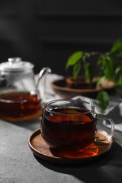 Photo of Tasty hot tea in cup on grey table, closeup