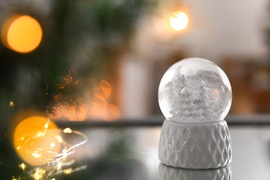 Decorative Christmas snow globe on mirror surface