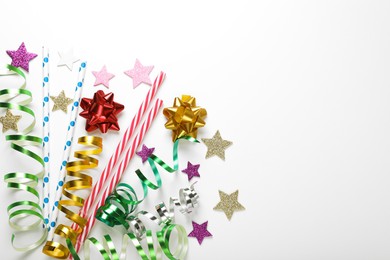 Photo of Straws, confetti and streamers prepared for birthday on white background, flat lay. Space for text