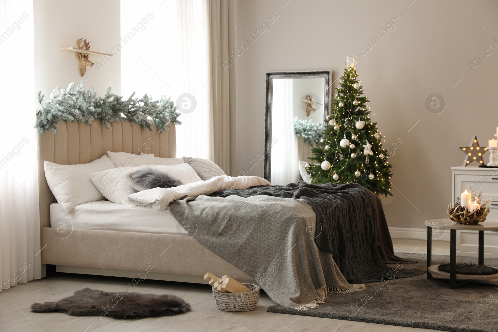 Photo of Beautiful decorated Christmas tree with fairy lights in bedroom interior