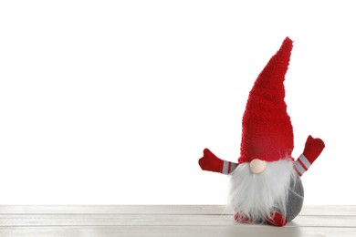 Photo of Funny Christmas gnome on wooden table against white background. Space for text