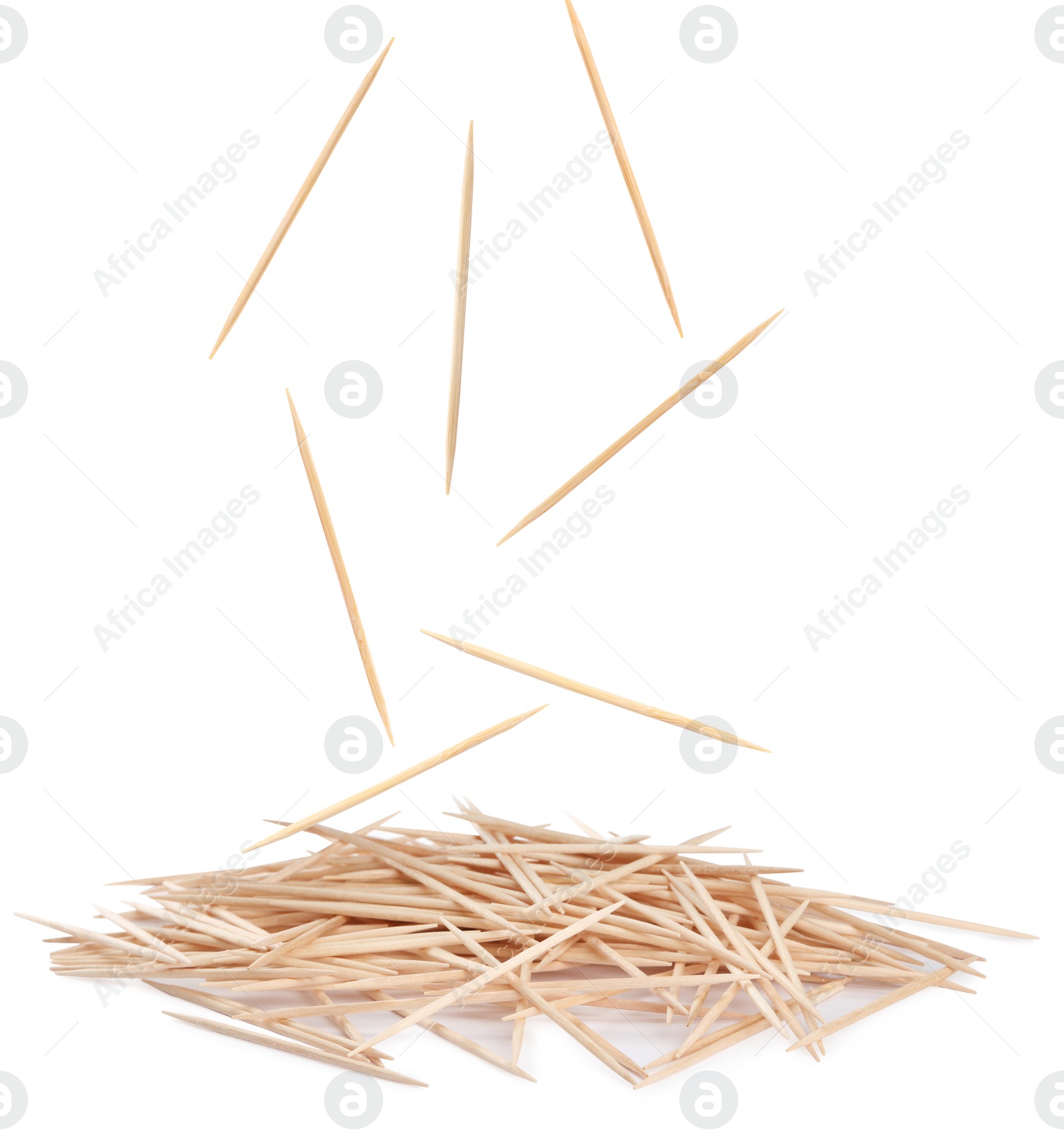 Image of Wooden toothpicks falling into pile on white background