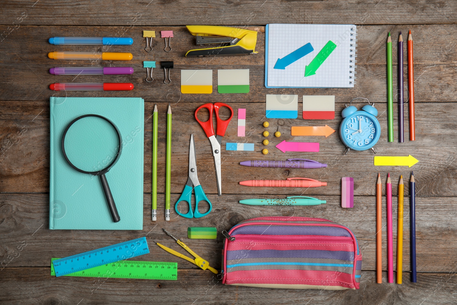 Photo of Different school stationery on wooden background, flat lay