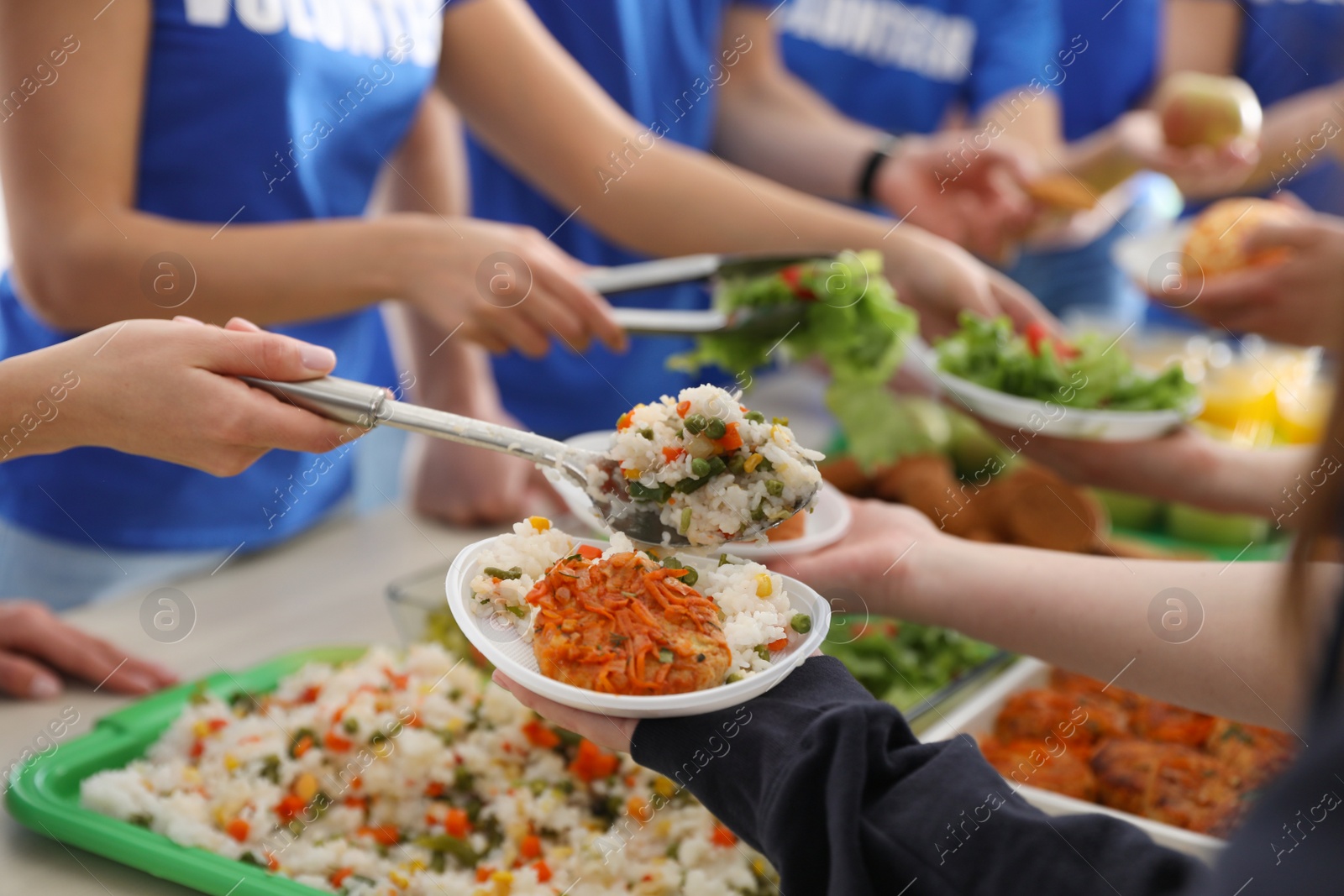 Photo of Volunteers serving food to poor people, closeup
