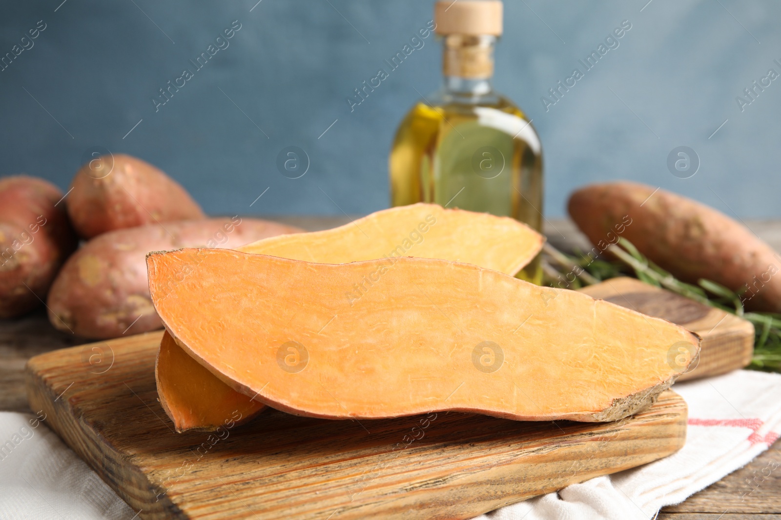 Photo of Wooden board with sweet potato on kitchen table