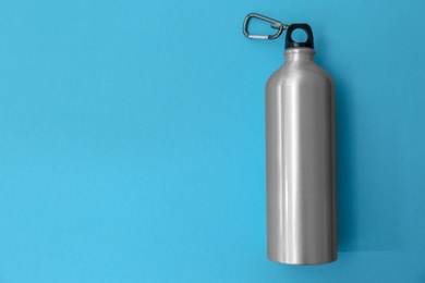 Photo of Sport bottle with space for text on color background, top view